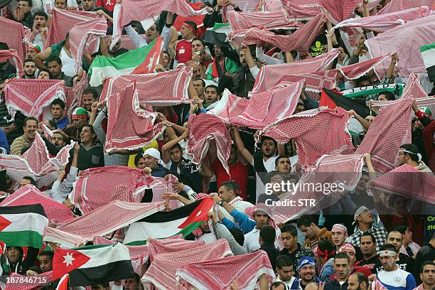 Jordanese fans wave their national flag and traditional Keffiyeh head scarfs as they cheer on their national team before their FIFA 2014 World Cup...