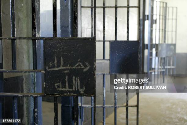 The words "God Help Me" are scrawled in Arabic on a prison door inside the notorious Abu Ghraib prison 16 September 2003 in Baghdad, parts of which...