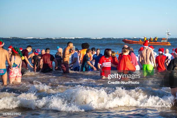 Daring participants are braving the icy waters of the North Sea during the Redcar Rotary Club Annual Boxing Day Dip in Redcar, United Kingdom, on...