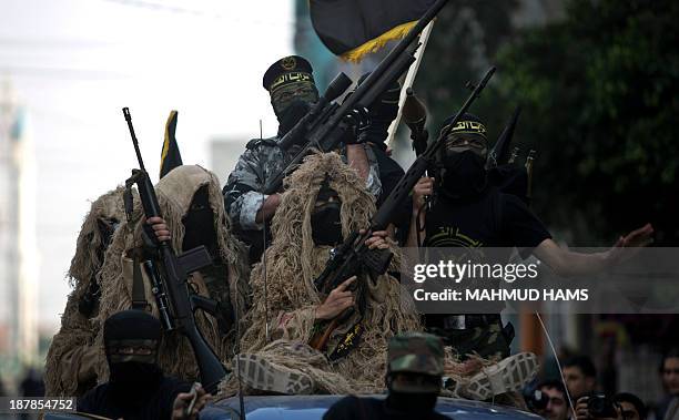 Members of the Palestinian Islamic Jihad movement parade with guns on November 13, 2013 in the streets of Gaza City during an anti-Israel march as...