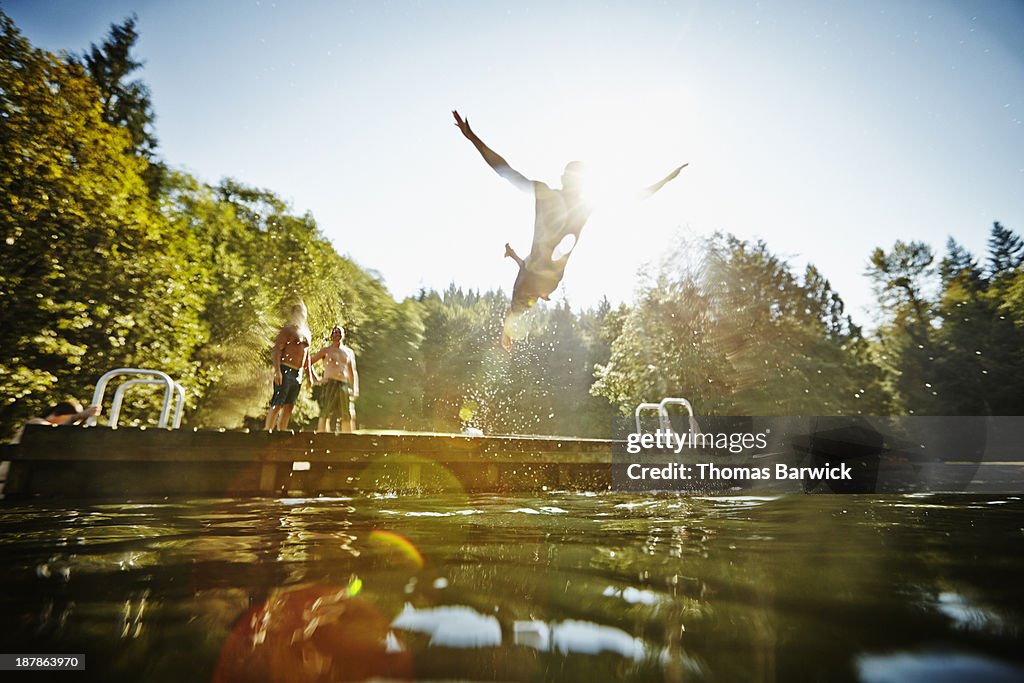 Man diving off dock into lake