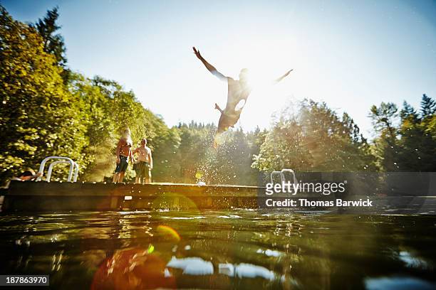 man diving off dock into lake - lake stock pictures, royalty-free photos & images