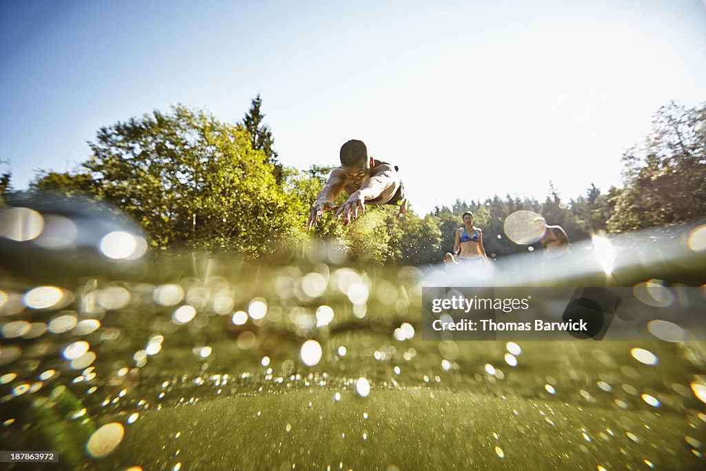 Man diving off dock into lake