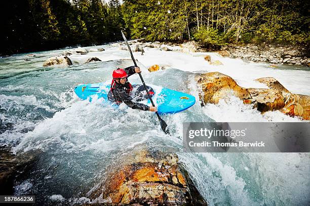 kayaker entering white water rapids - boat helm stock-fotos und bilder