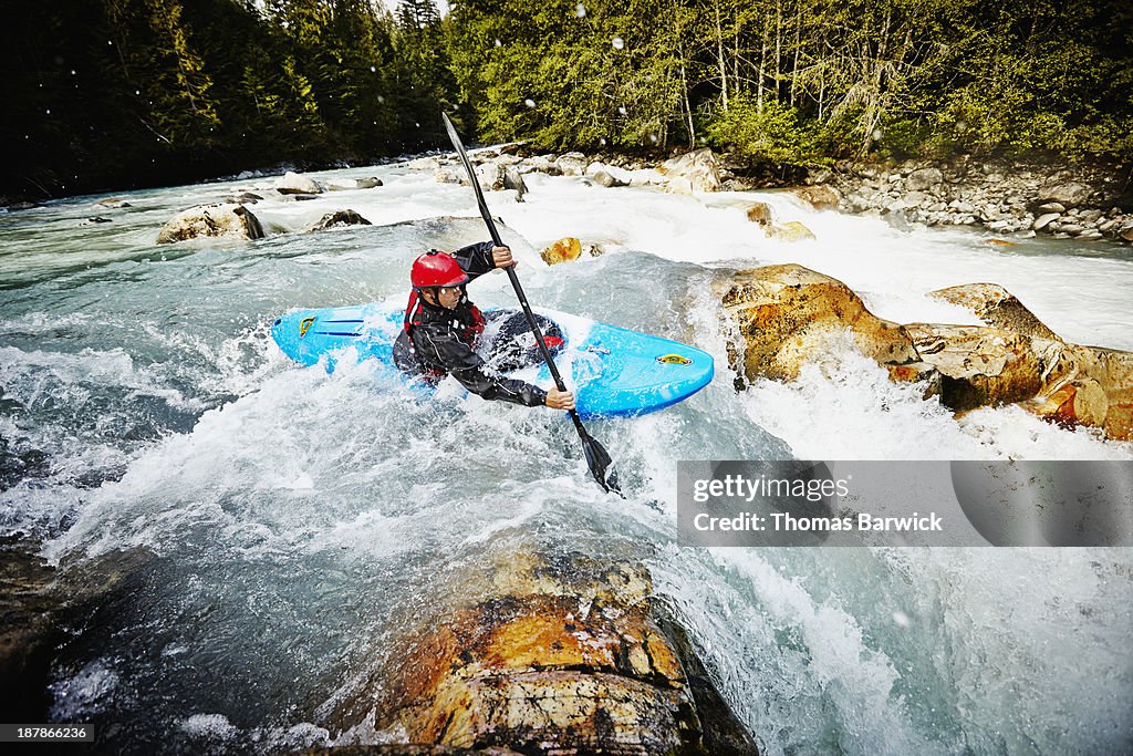 Kayaker entering white water rapids