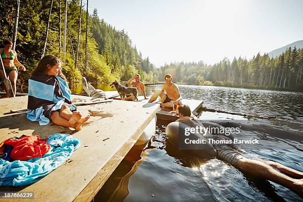 group of friends hanging out on floating dock - floating moored platform stock pictures, royalty-free photos & images