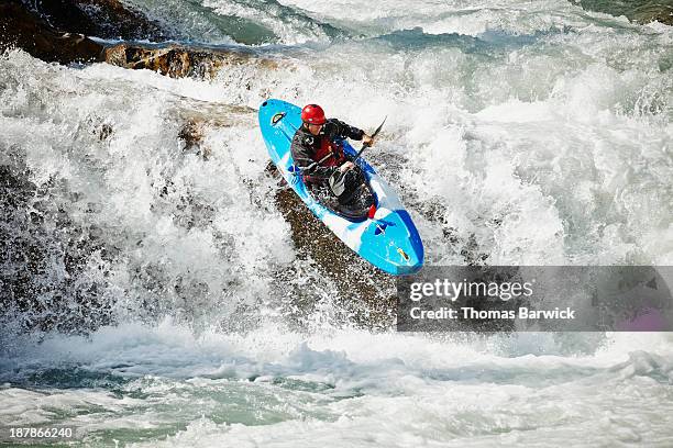 man kayaking off waterfall in white water rapids - stroomversnelling stockfoto's en -beelden
