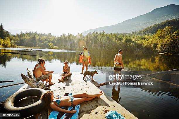 group of friends hanging out on floating dock - floating moored platform stock pictures, royalty-free photos & images