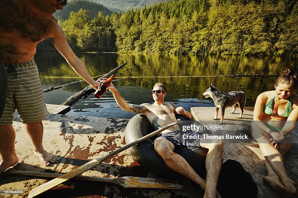 Group of friends hanging out sharing beer on dock