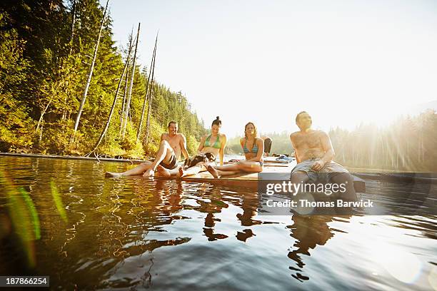 group of friends hanging out on floating dock - diving platform stock pictures, royalty-free photos & images