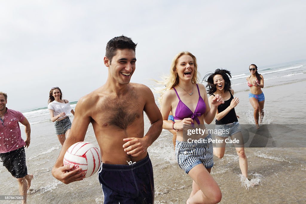 Group og young adults running out of sea