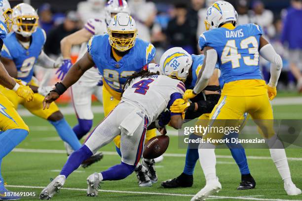 Alohi Gilman of the Los Angeles Chargers forces a fumble by James Cook of the Buffalo Bills in the fourth quarter at SoFi Stadium on December 23,...