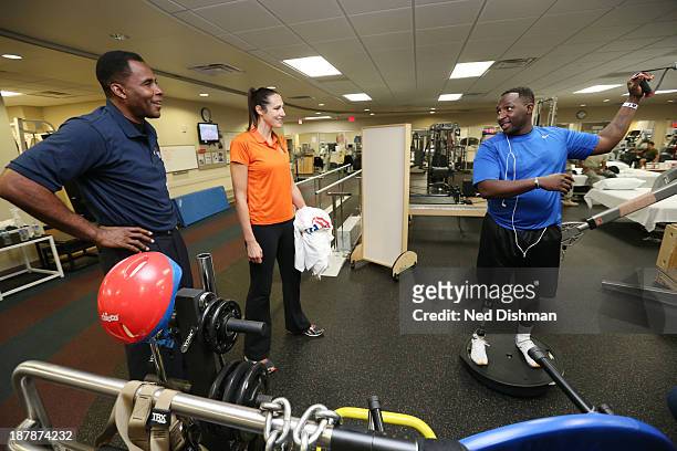 Legend Buck Williams and Ruth Riley of the Atlanta Dream speak with a patient during a visit to Walter Reed Medical Center on November 12, 2013 in...