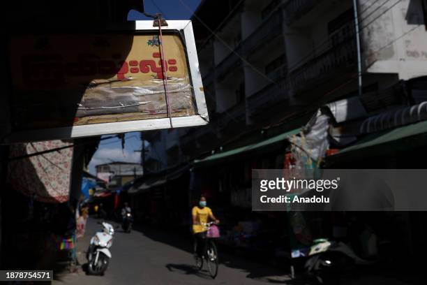 Motorbikes ride past a sign written in Burmese in Mae Sot, Thailand on November 24, 2023.