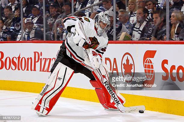 Goaltender Corey Crawford of the Chicago Blackhawks plays the puck along the boards during third period action against the Winnipeg Jets at the MTS...