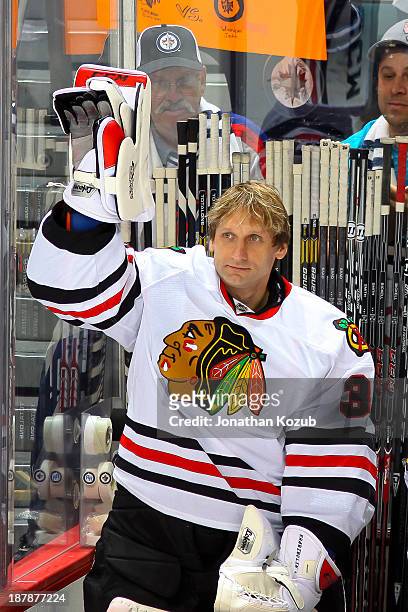 Goaltender Nikolai Khabibulin of the Chicago Blackhawks waves to the crowd after being acknowledged on the Jumbotron during a first period stoppage...