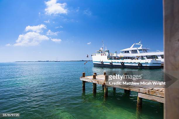 people diving from the bow of a docked ship - bay islands stock pictures, royalty-free photos & images