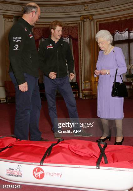 Ed Parker co-founder of 'Walking with the Wounded,' Britain's Prince Harry and his grandmother Queen Elizabeth II examine a 'pulk' during a reception...