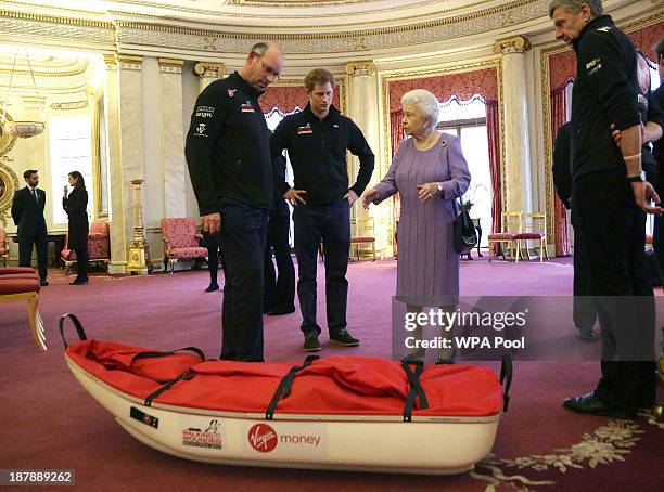 Ed Parker co-Founder of Walking with the Wounded and team mentor of Team USA, Prince Harry and Queen Elizabeth II examine a pulk belonging to TEAM UK...