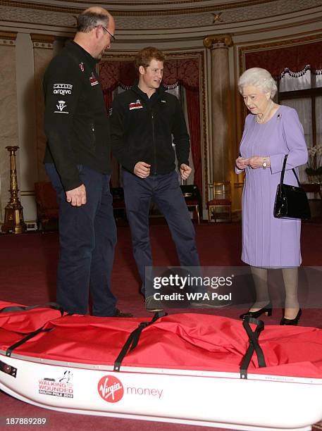 Ed Parker co-Founder of Walking with the Wounded and team mentor of Team USA, Prince Harry and Queen Elizabeth II examine a pulk belonging to TEAM UK...