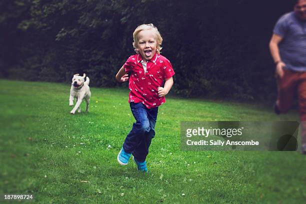 father and son walking the dog - boy running with dog stock pictures, royalty-free photos & images