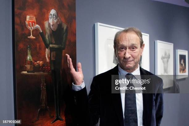 Paris mayor Bertrand Delanoe poses front of a painting of Pixar's film "Ratatouille" during the inauguration of the exhibition "PIXAR, 25 Years of...