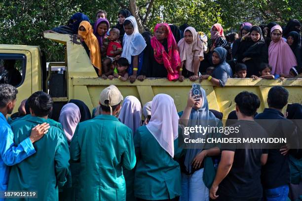 Rohingya refugees crowd into a vehicle for relocation to a nearby government building after demonstrating university students forced them out of the...