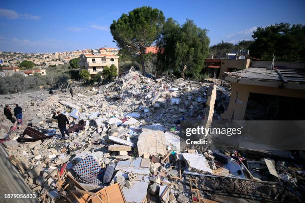 People check the rubble of a building in Bint Jbeil in southern Lebanon near the border with Israel, following Israeli bombardment the previous...