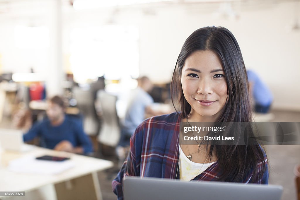 Businesswoman using laptop in modern office