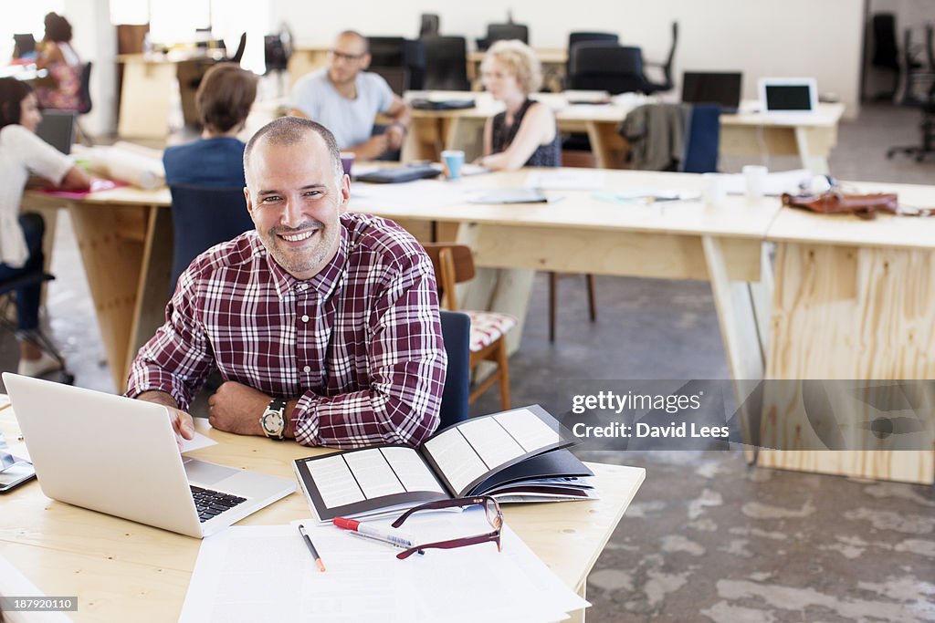 Portrait of businessman in busy modern office