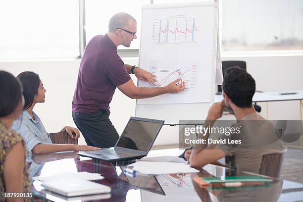 businessman pointing at flip chart in meeting - rotafolio fotografías e imágenes de stock