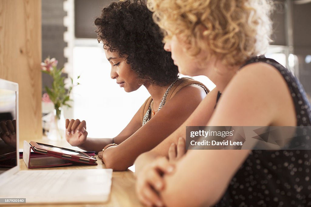 Businesswomen using digital tablet in cafe