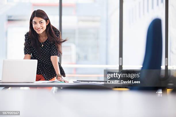 businesswoman using laptop in modern office - casual female business leader stock-fotos und bilder