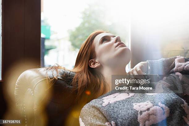 woman relaxing on sofa - oberteil frau stock-fotos und bilder