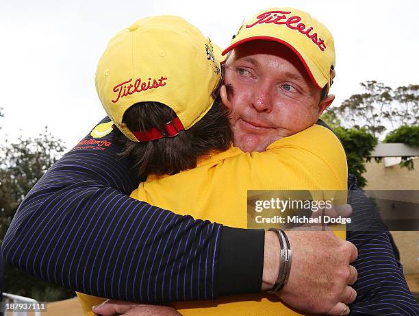 Jarrod Lyle of Australia hugs wife Briony Lyle after the 18th hole during round one of the 2013 Australian Masters at Royal Melbourne Golf Course on...