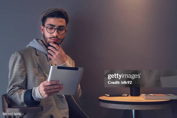 young handsome man in eyewear spending free time in coffee shop. - time life authors stock pictures, royalty-free photos & images