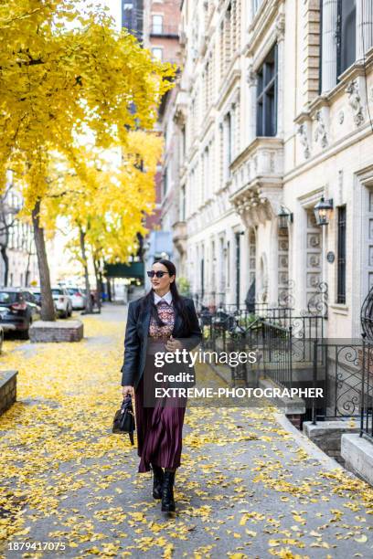 nicely dressed female new yorker enjoys autumn day - manhattan center stock pictures, royalty-free photos & images