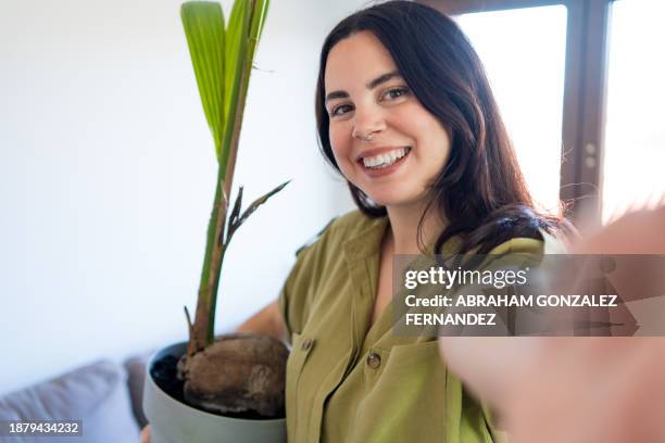 selfie of a woman enjoying taking care arranging her houseplants - flora gonzalez bildbanksfoton och bilder
