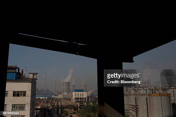 Vapor rises from cooling towers at a power plant, background, at the China Hongqiao Group Ltd. Aluminum smelting facility in Zouping, China, on...