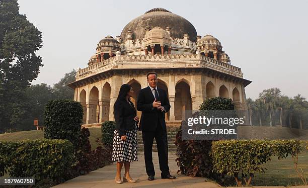 Britain's Prime Minister David Cameron speaks with an official from The British High Commission during a visit to Lodhi Gardens in New Delhi on...