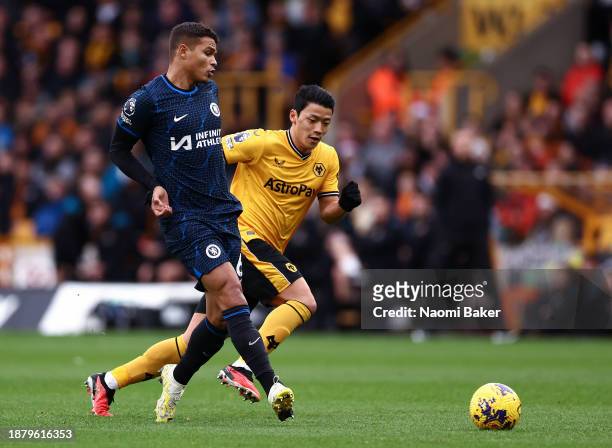 Thiago Silva of Chelsea passes the ball whilst under pressure from Hwang Hee-Chan of Wolverhampton Wanderers during the Premier League match between...