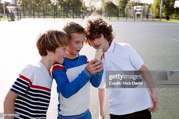 boys playing outside using mobile phone - só meninos - fotografias e filmes do acervo