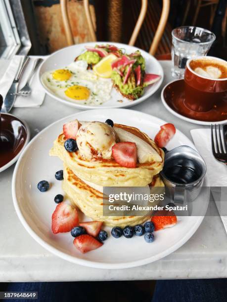 large stack of pancakes served with fresh fruits and butter in a restaurant - genomen met mobiel apparaat stockfoto's en -beelden
