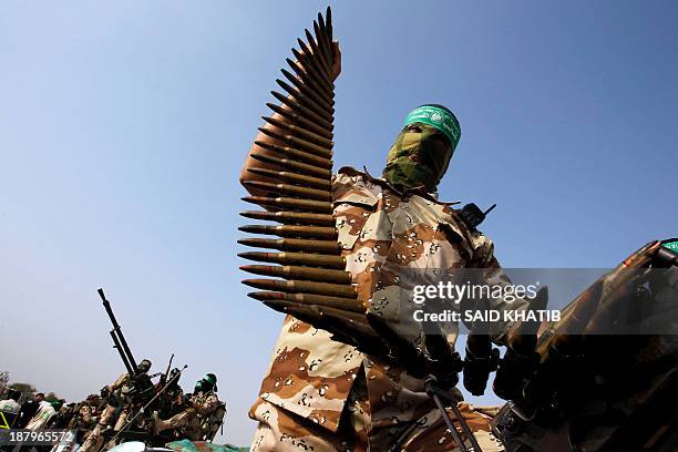 Masked member of the militant group Ezzedine al-Qassam Brigades, Hamas's armed wing, parades in Rafah, southern Gaza Strip, on November 14 during an...