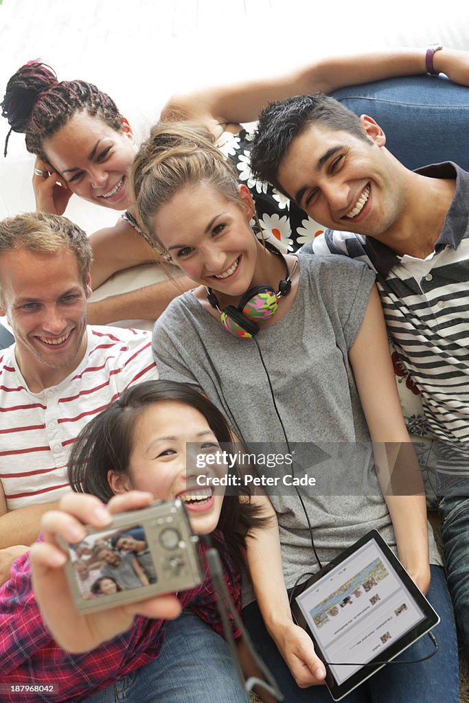 Young adults on sofa taking photo of themselves