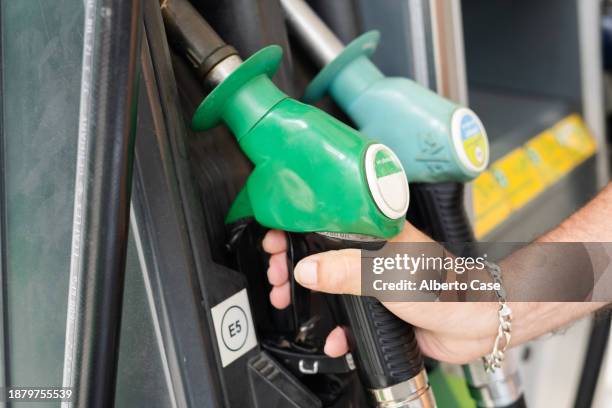 a man holding the gasoline hose - alberto stock-fotos und bilder