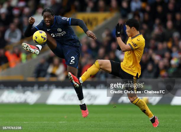 Axel Disasi of Chelsea passes the ball whilst under pressure from Hwang Hee-Chan of Wolverhampton Wanderers during the Premier League match between...