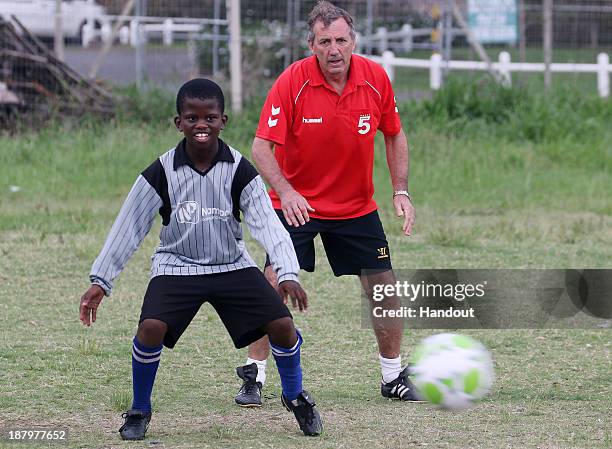 Alan Kennedy with kids during the Liverpool FC Legends Tour, CSI and Coaching Clinic at Siphosethu Primary School on November 14, 2013 in Mount...