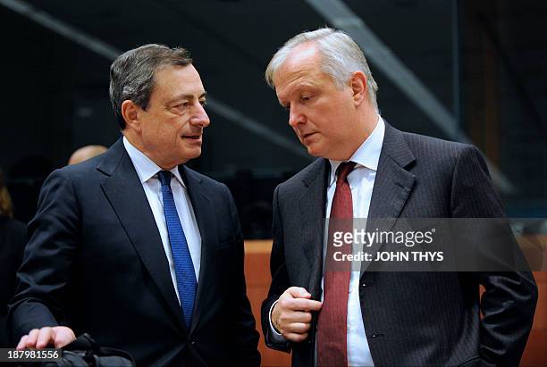 President of European Bank Mario Draghi speaks with EU commissioner for Economic and Monetary Affairs Olli Rehn prior to a Eurozone finance ministers...