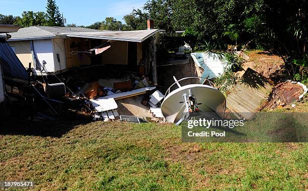 The rear portion of a residential home is consumed by a sinkhole November 14, 2013 in Dunedin, Florida. According to reports, the large sinkhole...